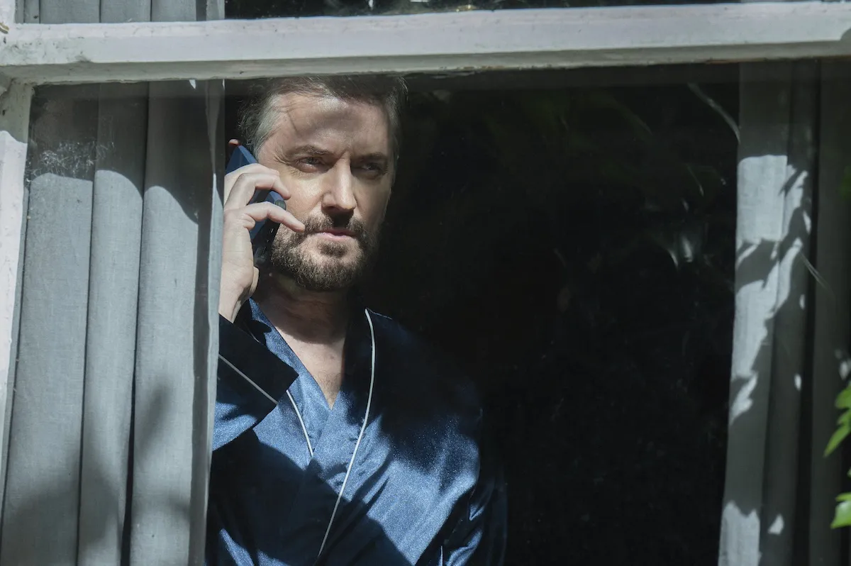 A man in a window with a cellphone to his ear in the Harlan Coben Netflix series 'Missing You'